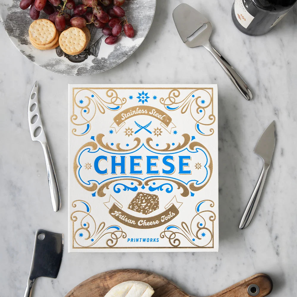 Cheese platter with a decorative cheese board, knife, and wine on a marble surface.