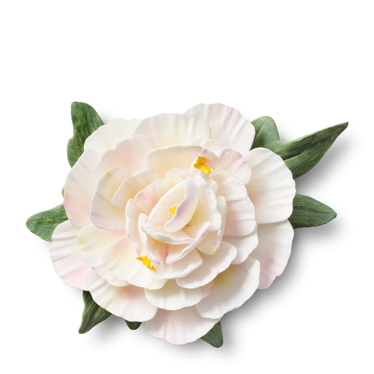 White porcelain flower with green leaves on a white background
