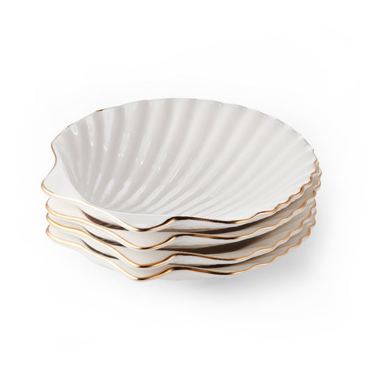 Set of four white ceramic plates with scalloped edges and gold trim on a white background