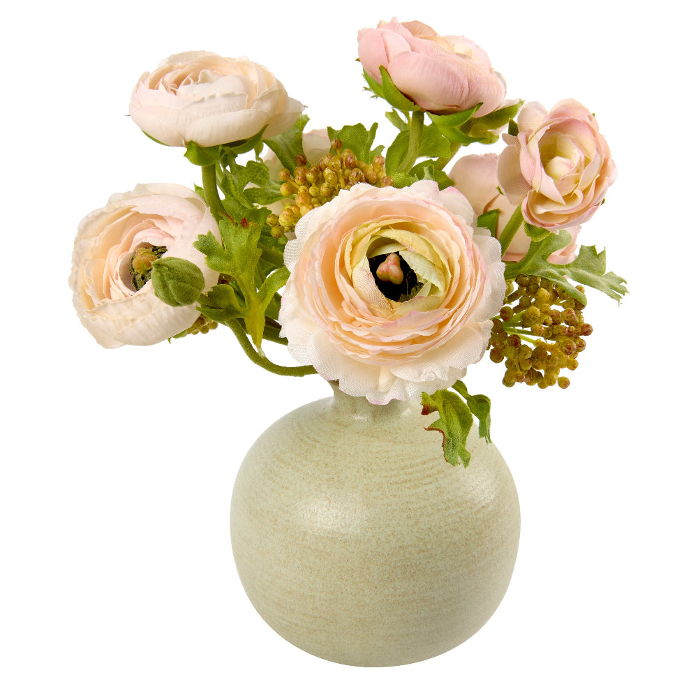 Bloom and Berry by Diane James Home is a bouquet of faux pale blush pink ranunculus flowers with green foliage arranged in a round, textured light sage green ceramic vase, isolated on a white background.