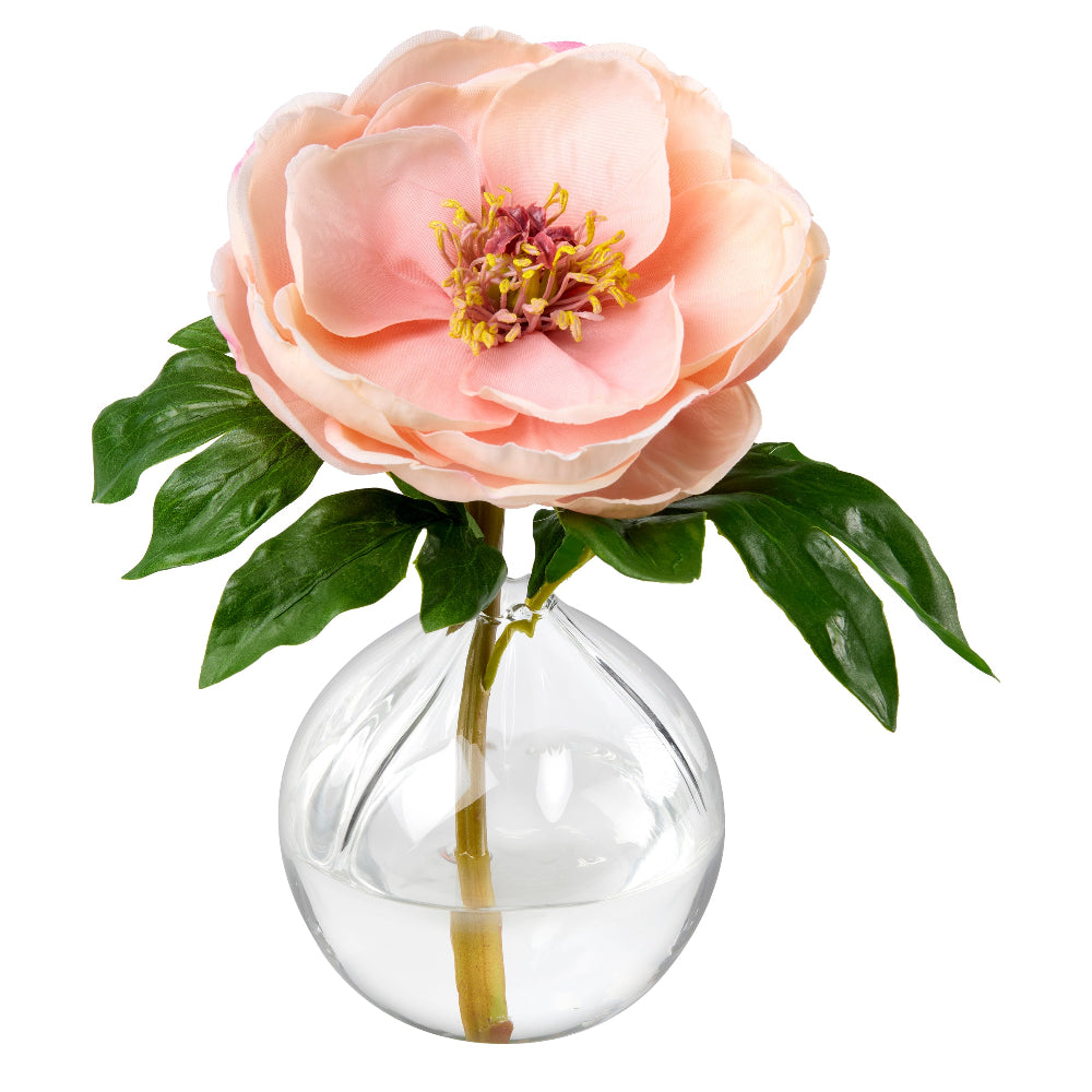 Bonnie Blush single artificial peach-pink peony flower with green leaves and a yellow center, displayed in a clear round glass vase on a white background made by Diane James Home.