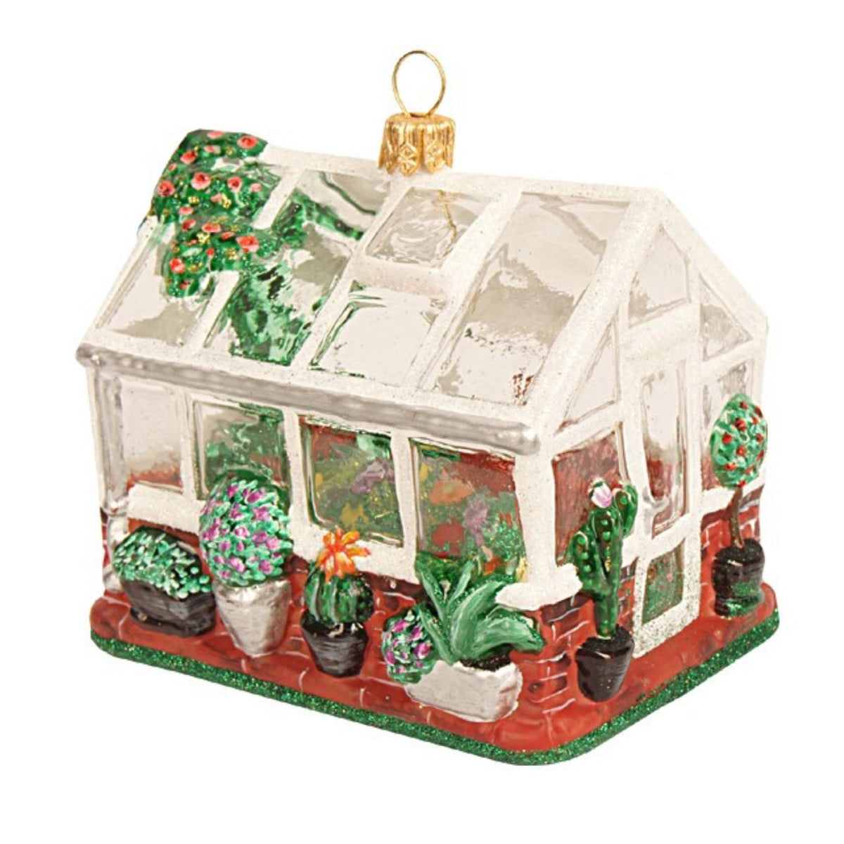 A decorative greenhouse ornament with a white frame, clear glass panels, potted plants, and a gold hanging loop, shown on a plain white background.