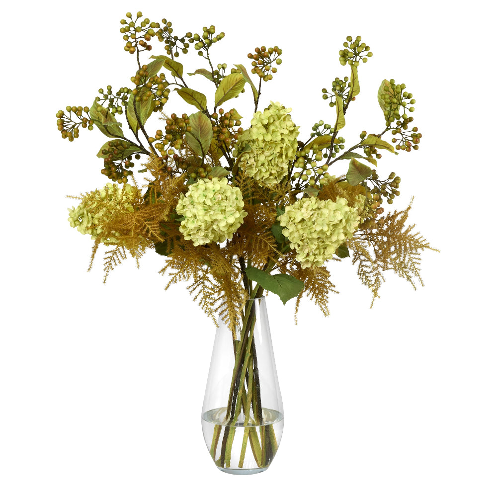 An artificial floral arrangement by Diane James Home featuring pale green hydrangea, olive-green leaves, and tan asparagus fern and berries, displayed in a clear glass vase against a plain white background.