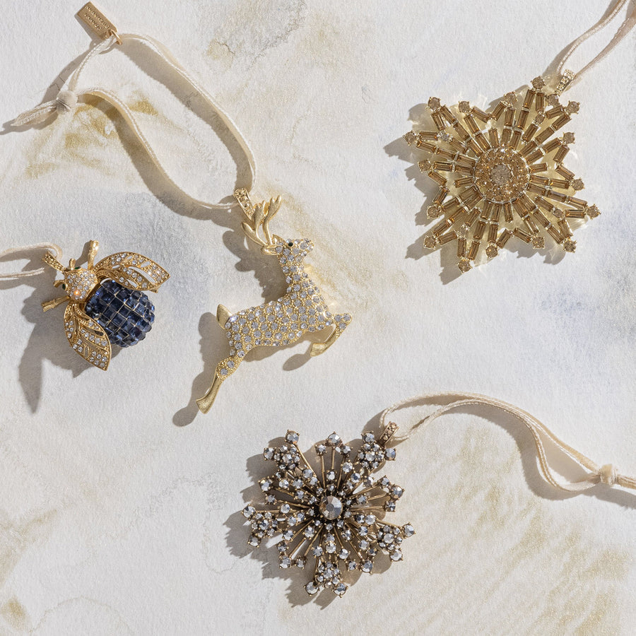 A selection of Joanna Buchanan holiday ornaments featuring stars, reindeer and bug