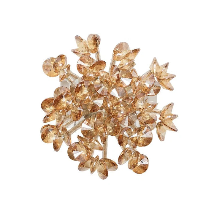 A cluster of clear faceted crystal flowers with warm amber-gold glitter, arranged on a plain white background.