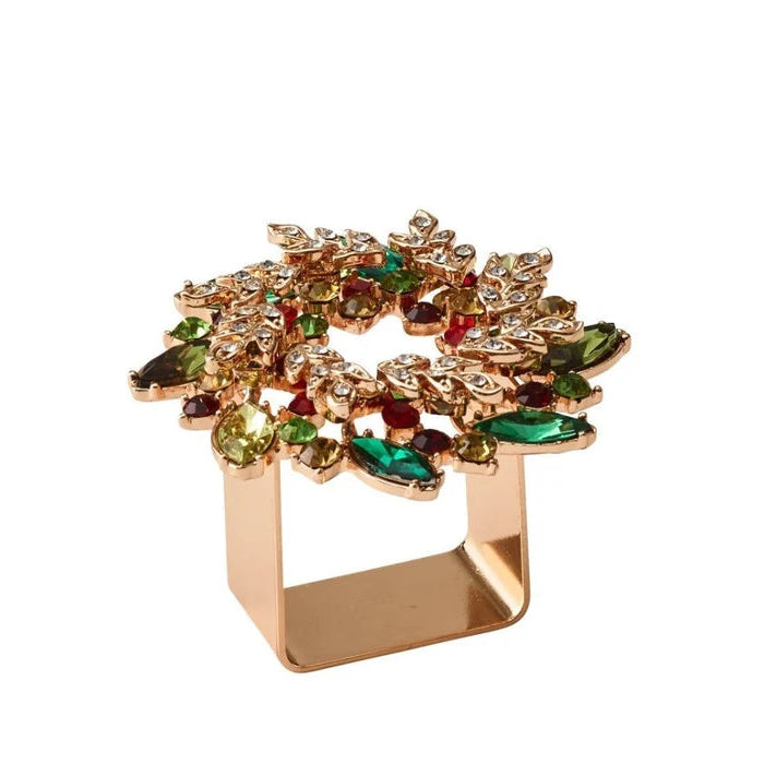 A gold-plated ring with a wide, open rectangular base and a decorative top featuring multiple faceted gemstones in green, red, and clear crystal, set against a plain white background.