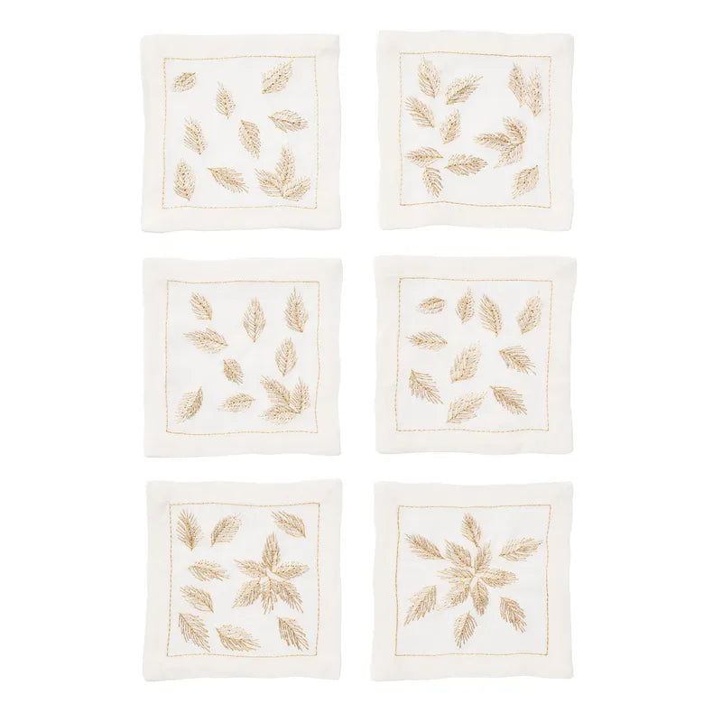 Six square whitelinen napkins arranged in a 3-by-2 grid on a white background. Eachnapkin features embroidered gold leaf motifs and a thingoldborder.
