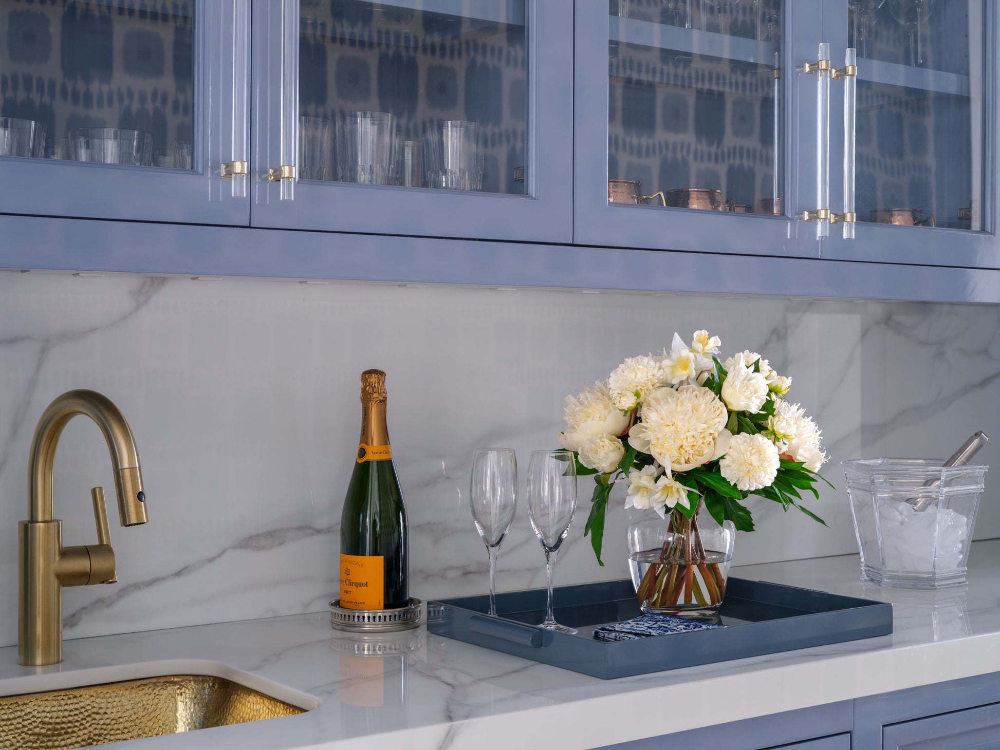 Modern bar with champagne bottle, glasses, and flowers by DIane James Home on a tray.
