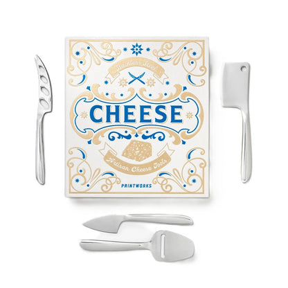 A cheese board set with four stainless steel tools arranged on a white background: a decorative cheese knife, a cleaver, a cheese spreader, and a cheese puller. A square printed box labeled 'CHEESE' and 'Printworks' sits behind them.