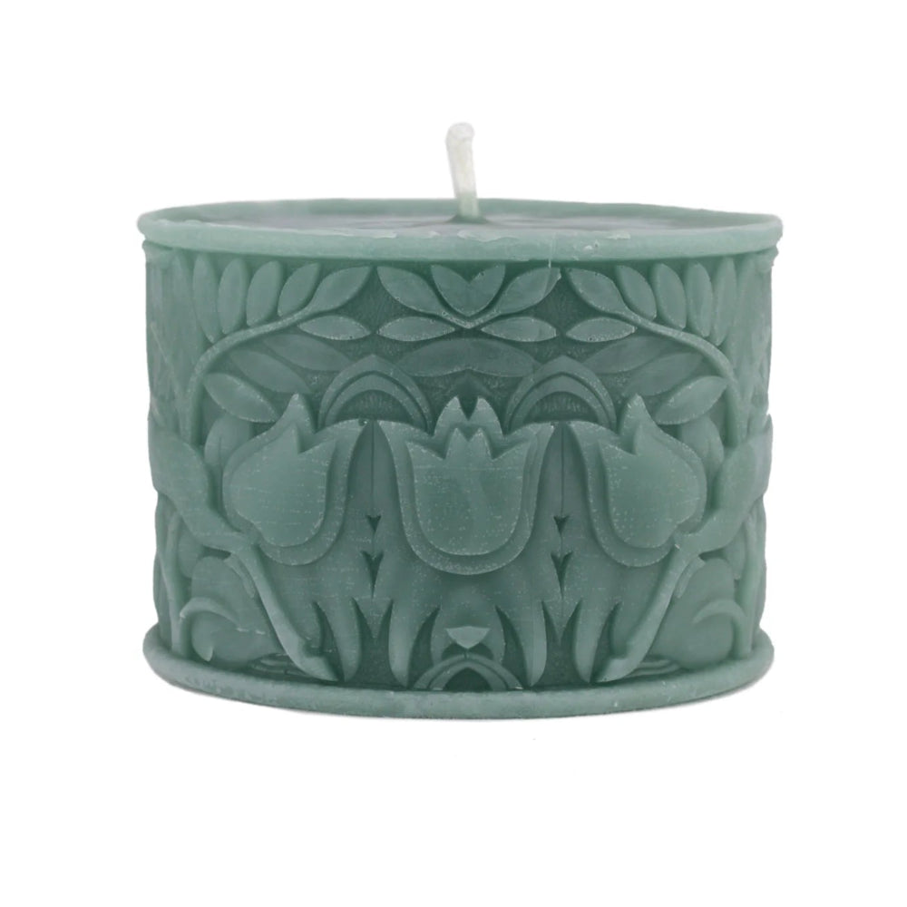 A sage green wax candle with a textured, embossed floral pattern and a single white wick, shown on a plain white background.