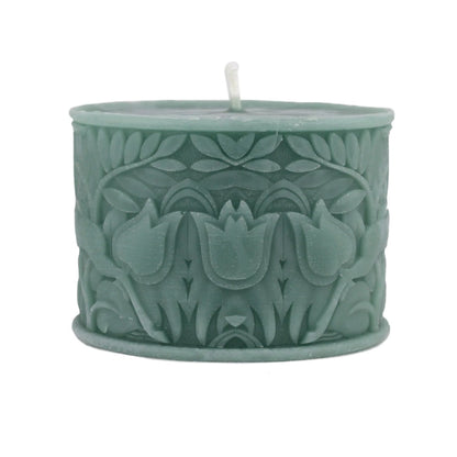 A sage green wax candle with a textured, embossed floral pattern and a single white wick, shown on a plain white background.