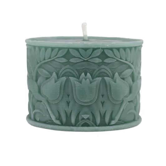 A sage green wax candle with a textured, embossed floral pattern and a single white wick, shown on a plain white background.