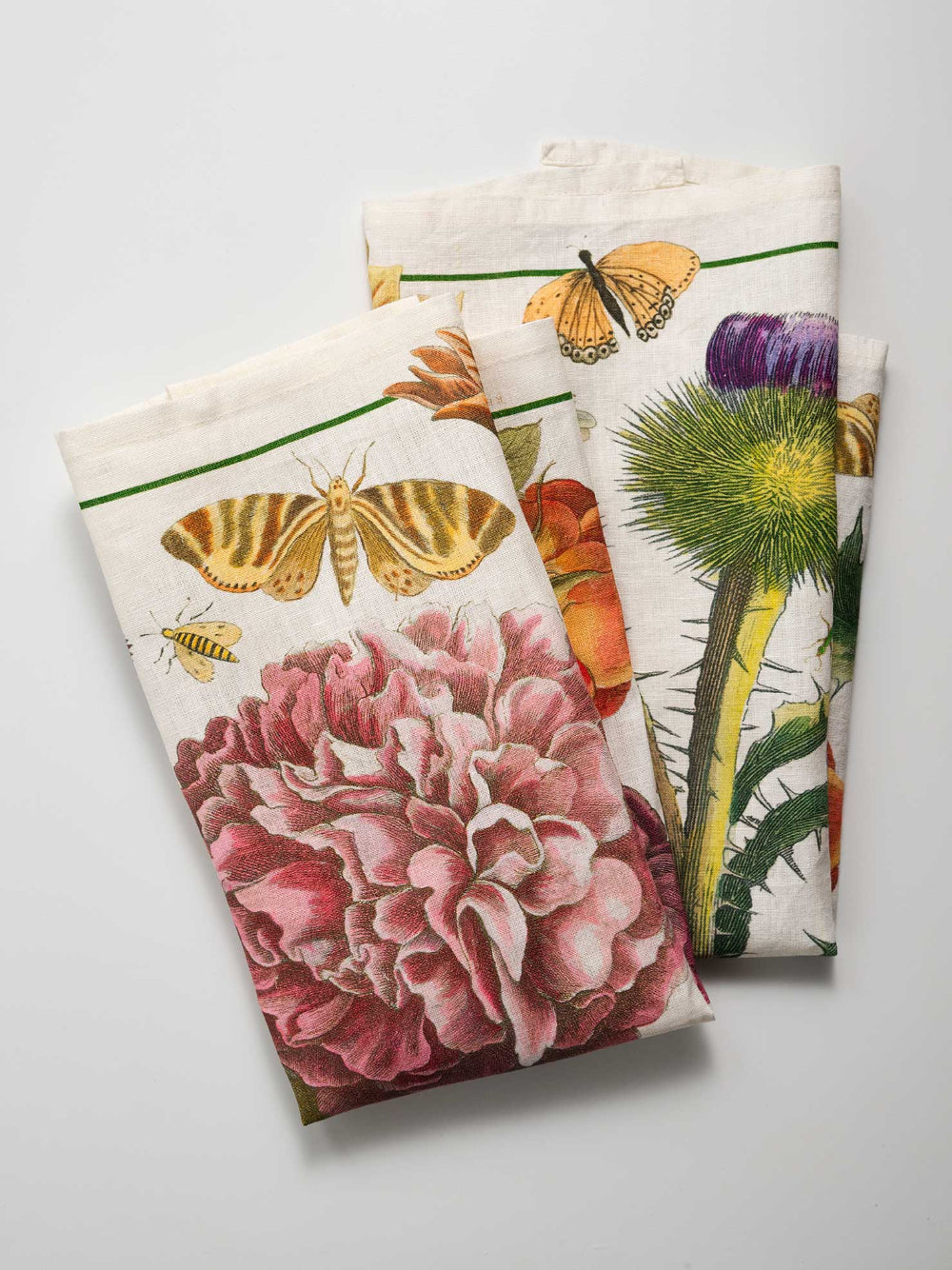Two decorative cotton tea towels with floral and butterfly designs on a white background