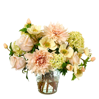 Soft Spoken by Diane James Home is an artificial floral arrangement featuring blush dahlias, roses, and hydrangeas with green foliage, presented in a clear glass vase on a white background.