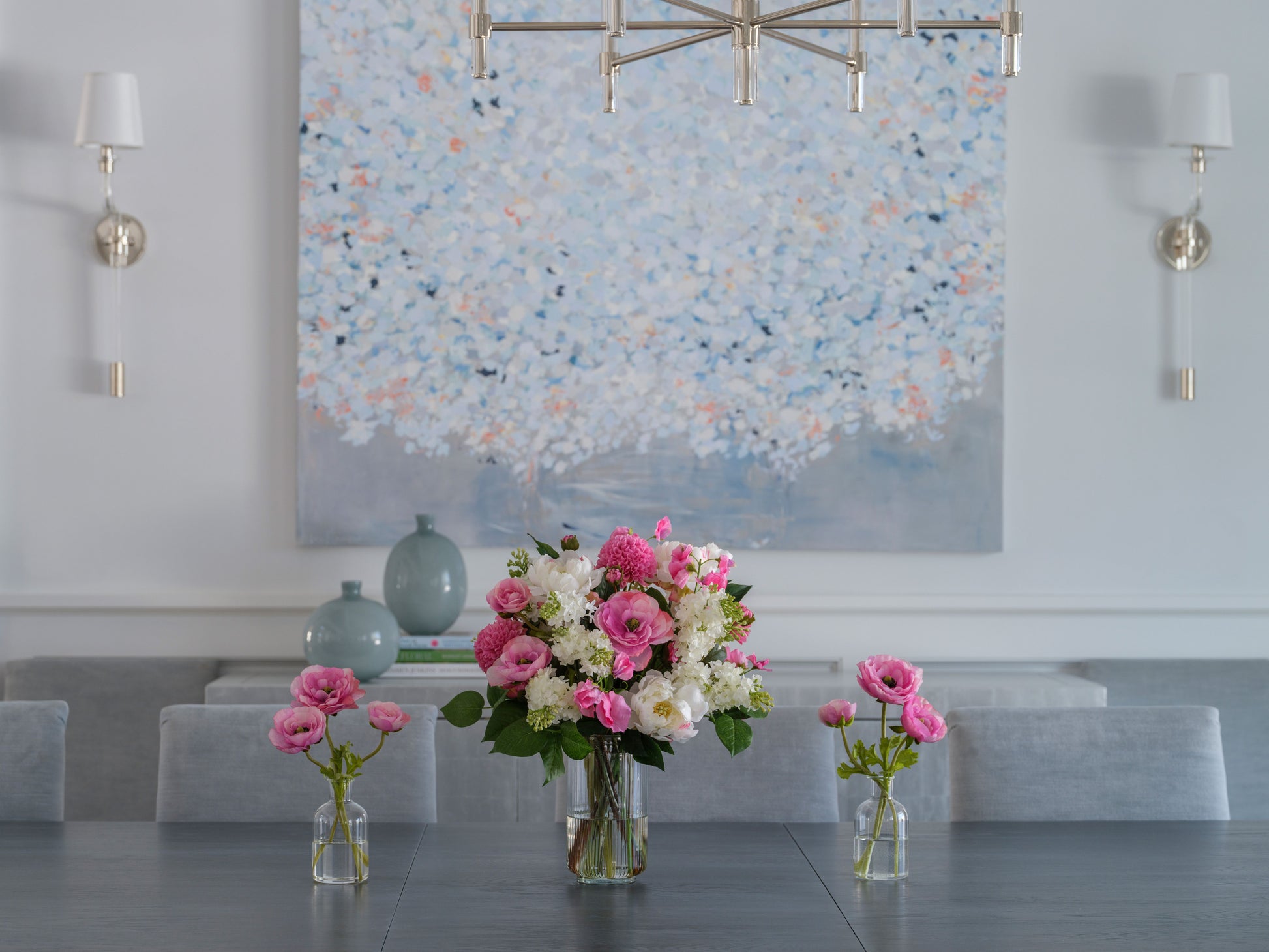 Faux floral arrangement by Diane James Home on a dining table with a wall painting in the background